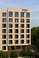 A modern building with the "OKKO HOTELS" sign, featuring a grid of windows and a flat facade.