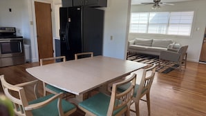A modern kitchen with a black refrigerator, wooden cabinets, and a dining area with a table and chairs. - Ideal location close to Texas Tech, University Medical Center, Covenant Hospital (Lubbock)