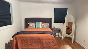 A bedroom with a bed, a chair, a small table, and a window with blinds. - Ideal location close to Texas Tech, University Medical Center, Covenant Hospital (Lubbock)