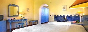 A hotel room with a bed, a desk with a chair, a wardrobe, and a lamp. - Amarestyle IGV Club Baia Samuele (Scicli)