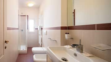 Un bagno con doccia, WC e lavandino.
