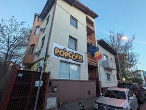 A building with a sign for a hostel and a flag.