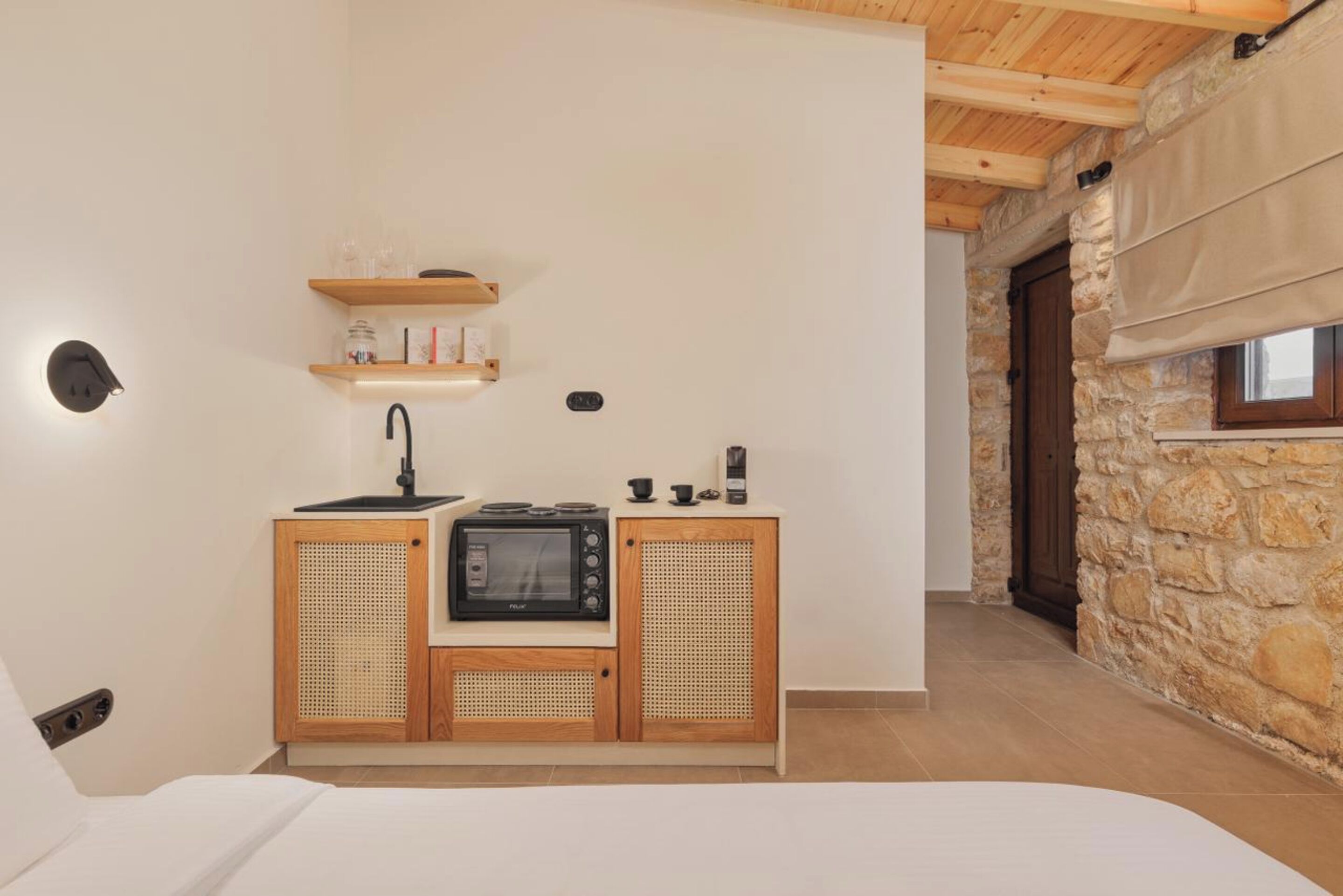A compact kitchen with a microwave, sink, and wooden cabinets.