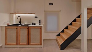 Una cocina moderna con un lavamanos, armarios y una escalera.