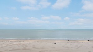 A wide beach with a clear sky and calm sea. - Apartment in Middelkerke With Sea View (Middelkerke)