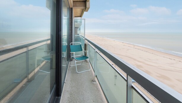 A balcony with a glass railing overlooking a beach. - Apartment in Middelkerke With Sea View (Middelkerke)