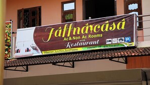 Un anuncio de un restaurante con habitaciones con aire acondicionado y sin aire acondicionado, número de contacto y detalles de ubicación.