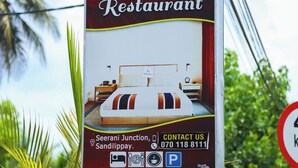 Cartel de un hotel que ofrece habitaciones con aire acondicionado y sin aire acondicionado, y cuenta con restaurante.