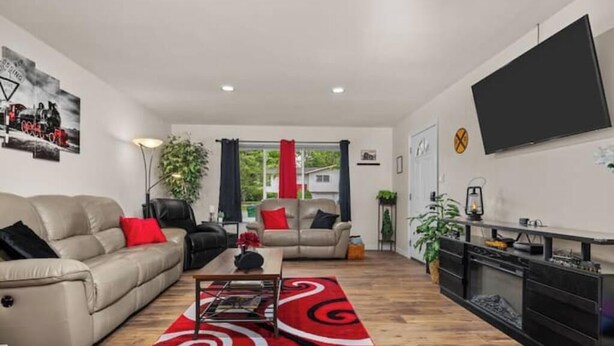 A modern living room with a sofa, a coffee table, and a TV.