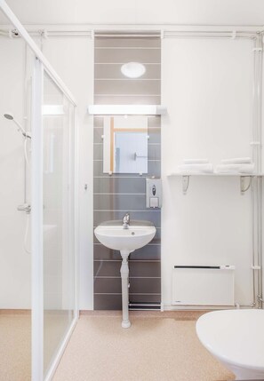 A modern bathroom with a glass shower enclosure, a pedestal sink, and a toilet.