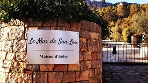A stone wall with a sign reading "Le Mas de San Lou Maison d'hôtes". - Le Mas de San lou (Cabasse)