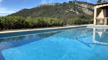 Una piscina al aire libre de temporada, sombrillas