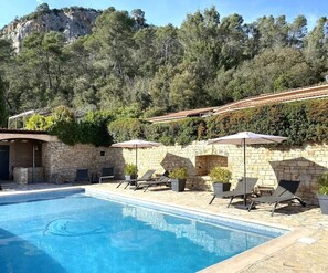 Een seizoensgebonden buitenzwembad en parasols bij het zwembad