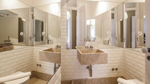 Un baño moderno con dos lavamanos, un inodoro y una ducha.