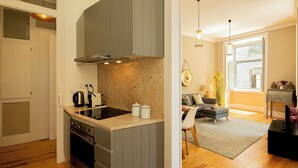 Una cocina moderna con armarios grises, estufa integrada y un amplio ventanal.