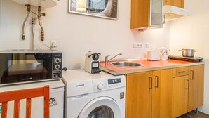 A compact kitchen with a microwave, toaster, sink, and washing machine. - 1 Bed Flat - Sleeps 4 - Pets - Wifi (Prague)