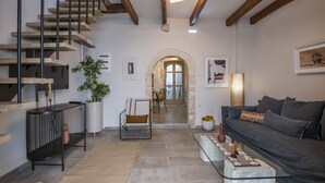 A modern living room with a staircase, a sofa, a coffee table, and a dining area. - Golden Theros villa,Village Experiene in Maroulas (Maroulas)
