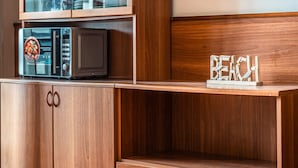 Een houten kast met een magnetron en een houten plank waarop een bordje 'BEACH' staat.