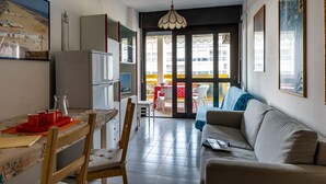 A compact living space with a kitchenette, a dining area, and a sofa.
