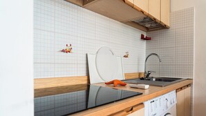A kitchen with a dishwasher, a sink, and a stove. - Cozy Apartment With Sunny Terrace in Bibione (San Michele al Tagliamento)