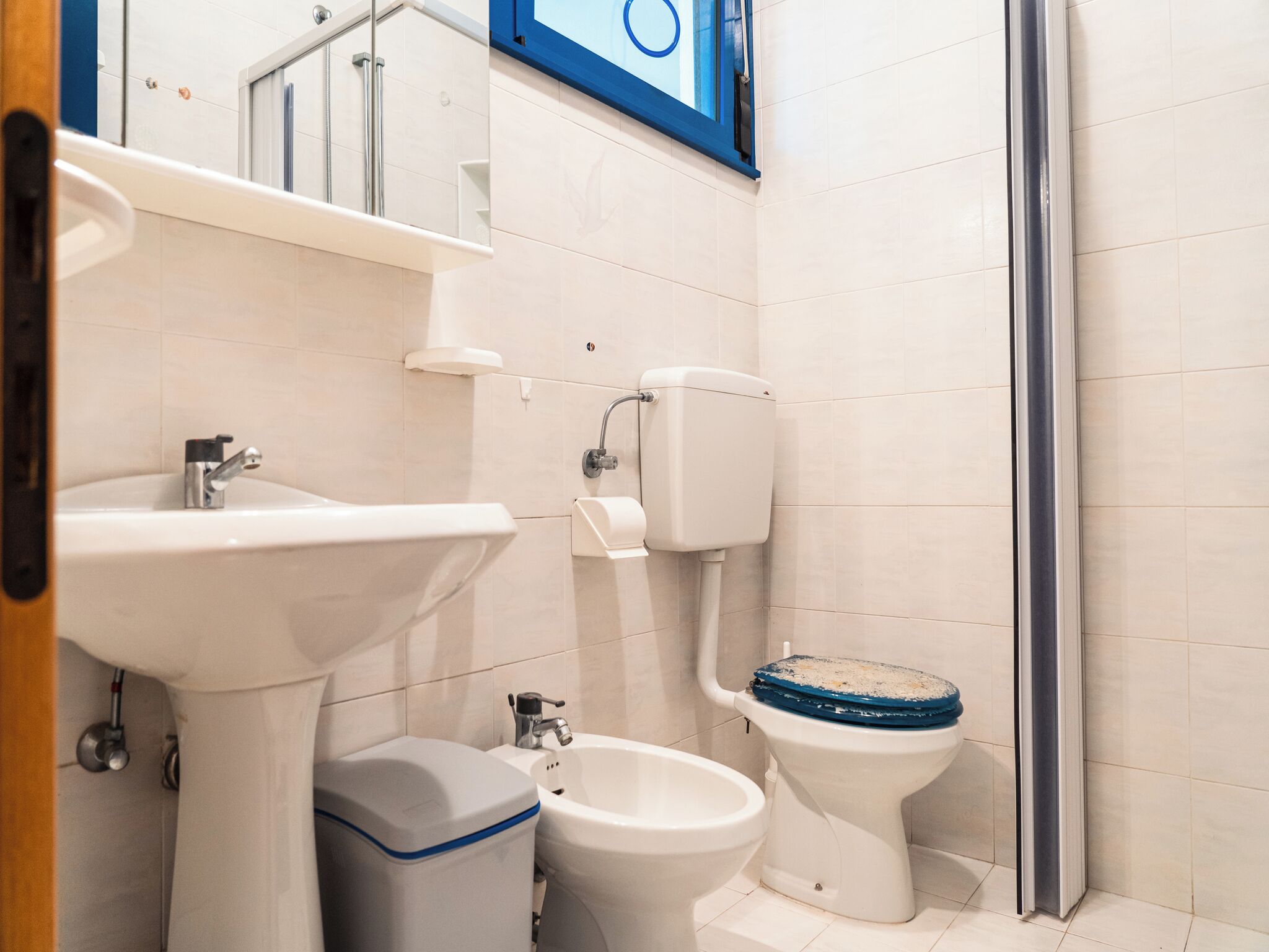 A modern bathroom with a sink, bidet, toilet, and shower.