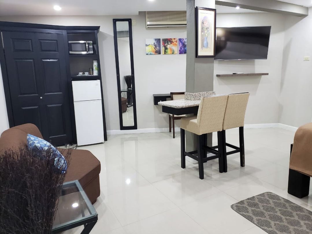 Un espai habitable compacte amb petita cuina, zona de menjador i zona de seients.