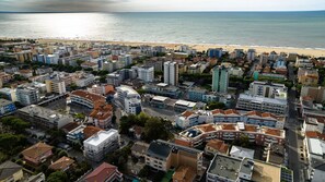 Vue aérienne d’une ville côtière, avec une plage en arrière-plan.