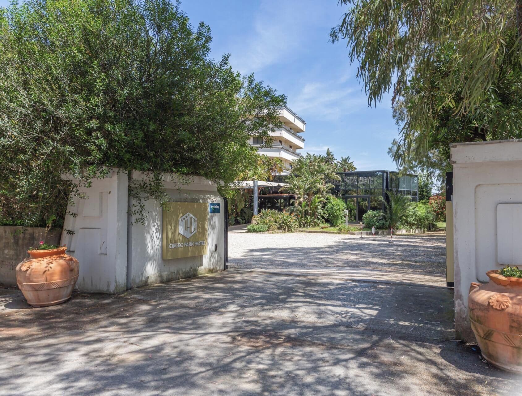 L’entrée d’un hôtel, avec une allée pavée menant à un bâtiment doté de balcons.