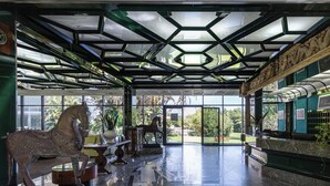 A spacious lobby with a glass ceiling, a horse statue, and a reception desk.