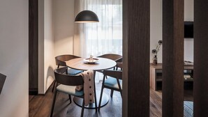 A modern dining area with a round table, chairs, and a pendant light.
