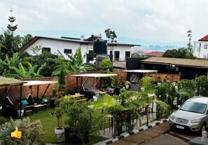 A residential area with a white building, a water tank, and a parked car. - CHALWE HOTEL APART (Kigali)