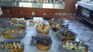 Una barra de buffet con diversos alimentos en cestas, una estación de bebidas y un fondo de pared de ladrillo.