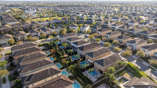A residential area with multiple houses, a central swimming pool, and well-maintained lawns. - Classic 8bd house - Encore Reunion Close to Disney (Kissimmee)