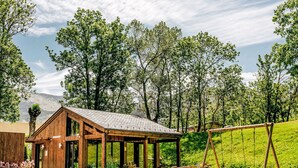 A wooden cabin with a sloped roof, surrounded by lush greenery and trees. - Apartment Ferreries with heated swimming pool, garden, WiFi, equipped kitchen (Saillagouse)