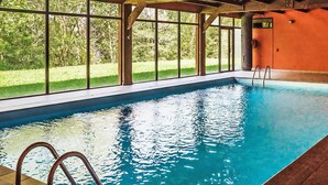 An indoor swimming pool with clear glass walls, a tiled floor, and a ladder leading into the pool. - Apartment Ferreries with heated swimming pool, garden, WiFi, equipped kitchen (Saillagouse)