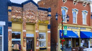 A street view with a brick building housing a pharmacy and a soda fountain. - The Bluegrass Railway Inn (Midway)