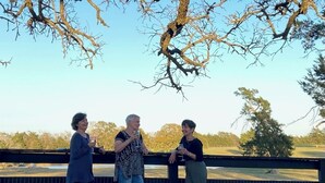 Three people standing by a fence with a view of a park and trees. - 3-Br Nature Oasis in rolling hills of Burton, 15 minutes from Round Top (Burton)