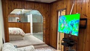 Une pièce comprenant un canapé, un téléviseur et un escalier menant à un niveau supérieur.