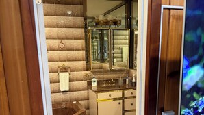 Une salle de bain avec une baignoire, un meuble-lavabo avec un miroir et des toilettes.