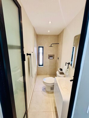 A modern bathroom with a toilet, sink, and shower. - Rose’s Grotto Room 4, Rose's Grotto - Room 4 The Mermaid and The Pearl Hotel (Isla Mujeres)