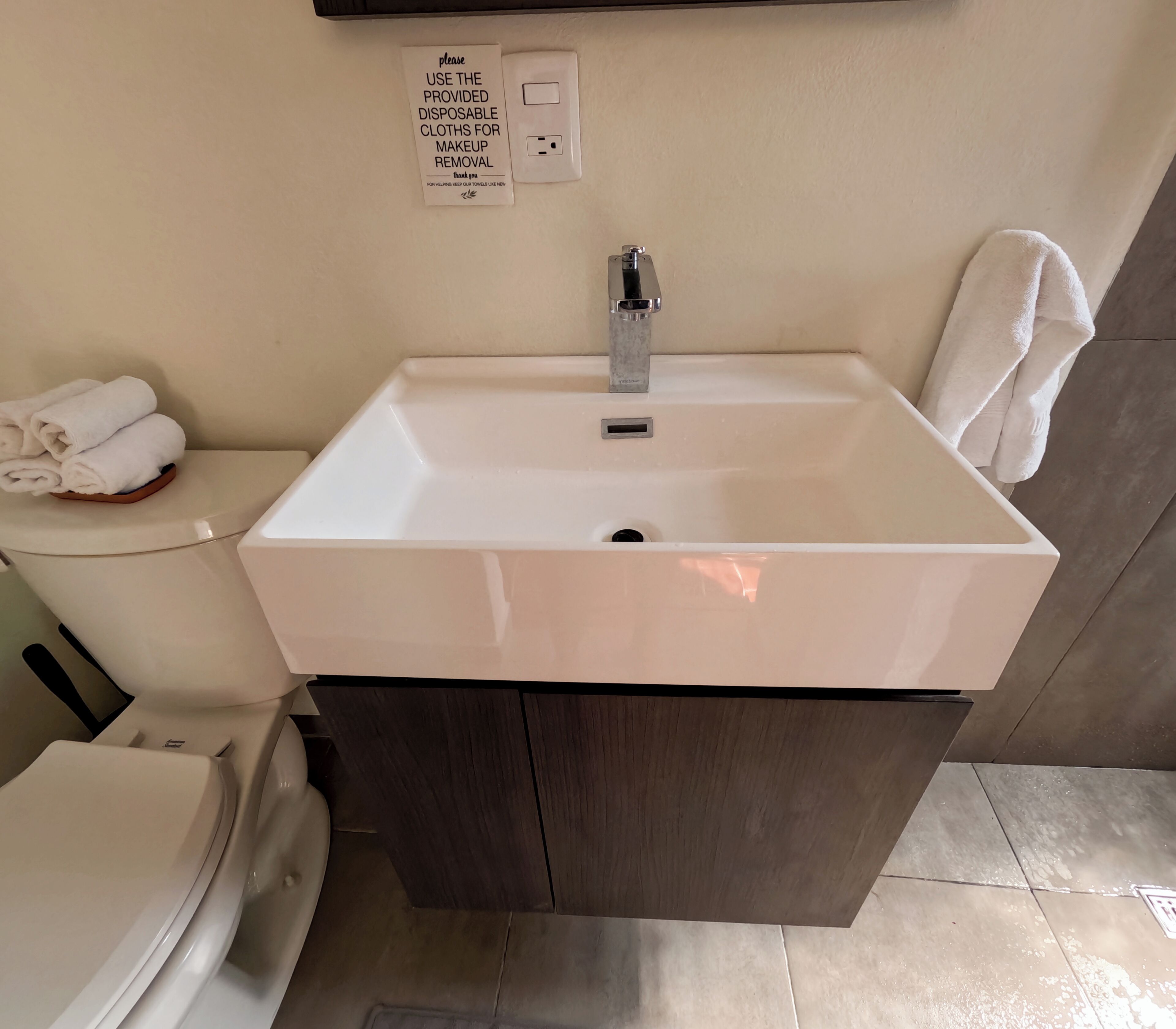 A bathroom with a white sink, a toilet, and a towel rack.