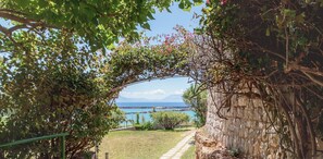 Un arco de entrada da a vistas de una masa de agua y un paisaje distante.