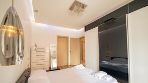 Un dormitorio moderno con una cama grande, un armario y una zona de ducha.