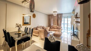 Una sala moderna con una mesa de comedor de vidrio, sofás cómodos y decoración elegante.