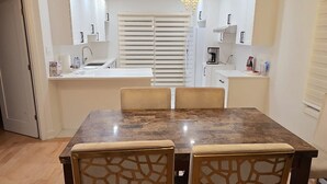 Un espace de restauration moderne avec une table en marbre, des chaises en bois et un lustre.