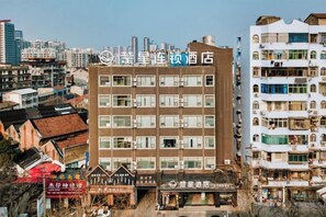 Ein mehrstöckiges Hotel mit moderner Fassade, mehreren Balkonen und freiem Blick auf die umliegende Stadt.