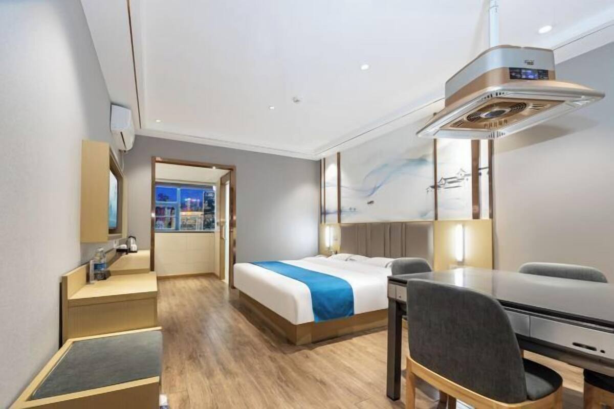 Habitación de hotel con cama, escritorio, silla y vista a la ciudad.