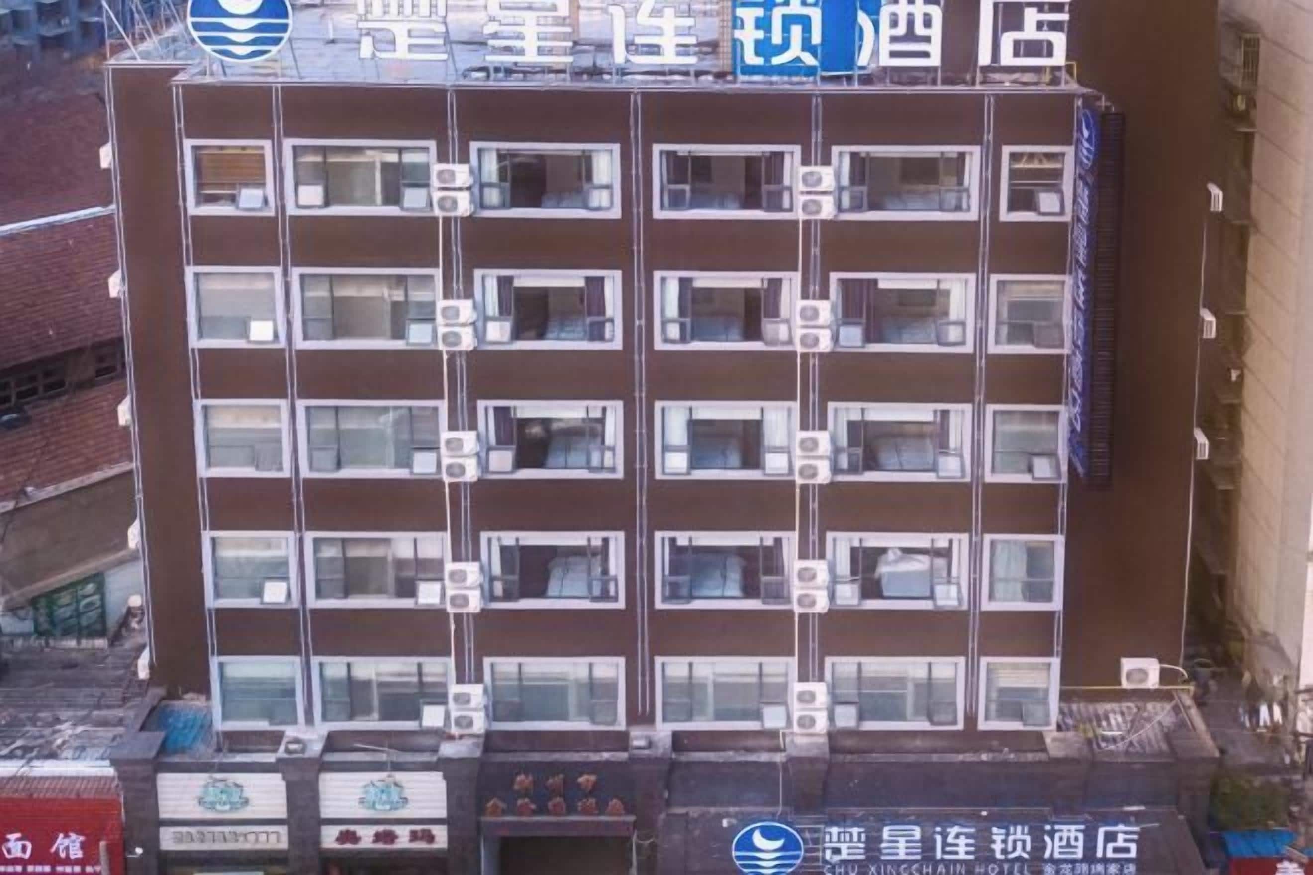 A multi-story hotel with a uniform facade, multiple balconies, and a series of air conditioning units.