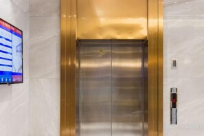 An elevator with a digital display on the wall to the left. - Rui Jia Business Hotel (Jingzhou)