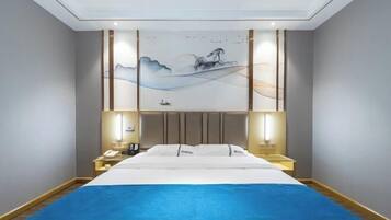 Een hotelkamer met een groot bed, nachtkastjes, een kunstwerk aan de muur en een plafondlamp.